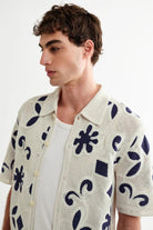 Man wearing a patterned shirt with a white background