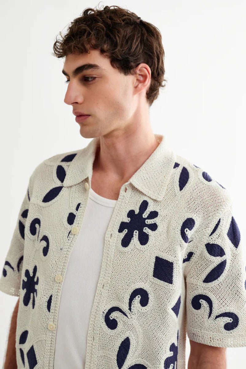 Man wearing a patterned shirt with a white background