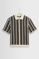 Black and white striped shirt on a hanger against a light gray background