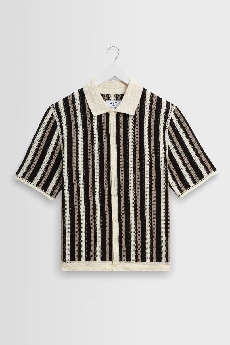 Black and white striped shirt on a hanger against a light gray background