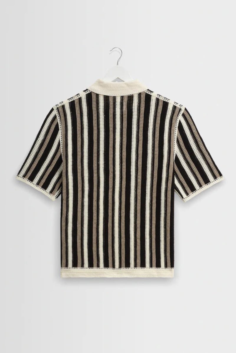 Black and white striped shirt on a hanger against a light gray background