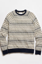 Striped sweater with navy and white stripes on a light gray background
