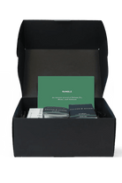 Black box with a green card and two items inside on a white background