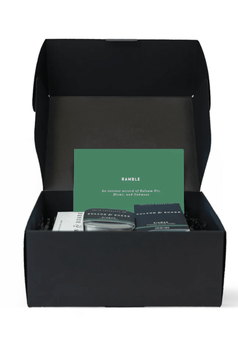 Black box with a green card and two items inside on a white background