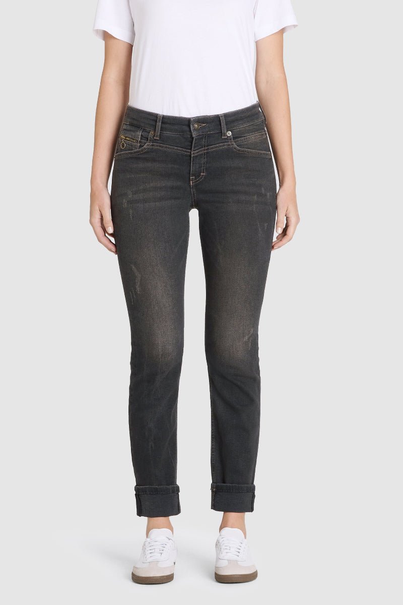 Person wearing black jeans and a white t-shirt on a light gray background