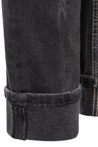 Close-up of black denim jeans with rolled-up hem on a white background