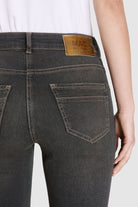 Dark gray jeans with a brand label on a plain background