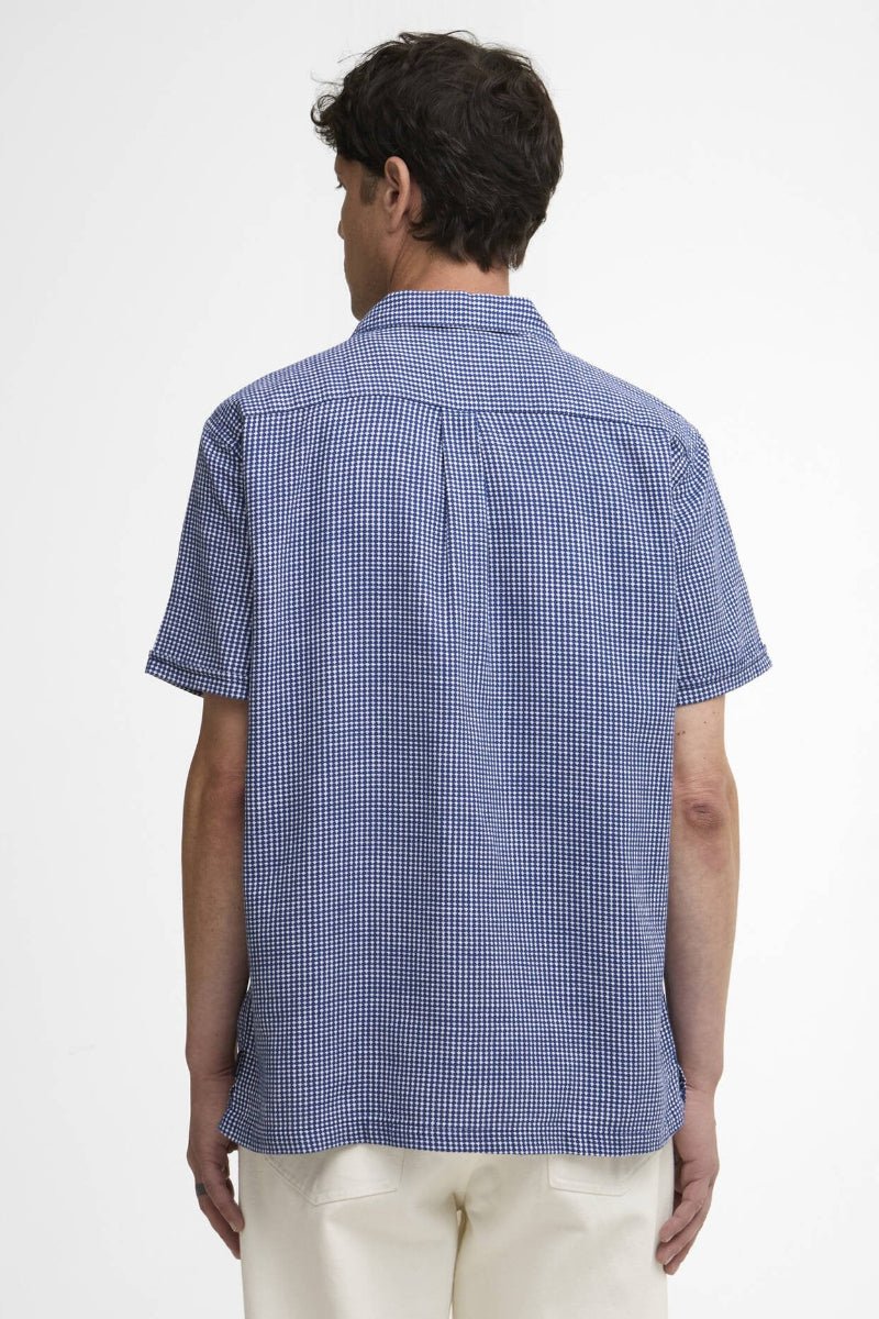 Person wearing a blue checkered shirt on a white background