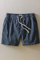 Blue shorts with a white drawstring on a beige background