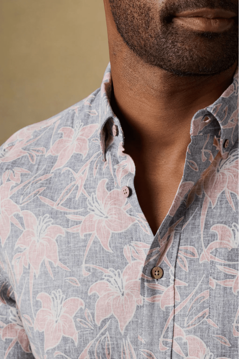 Man wearing a floral patterned shirt with a neutral background