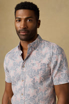 Man wearing a patterned shirt against a beige background