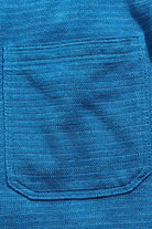 Close-up of a blue textured fabric with a pocket