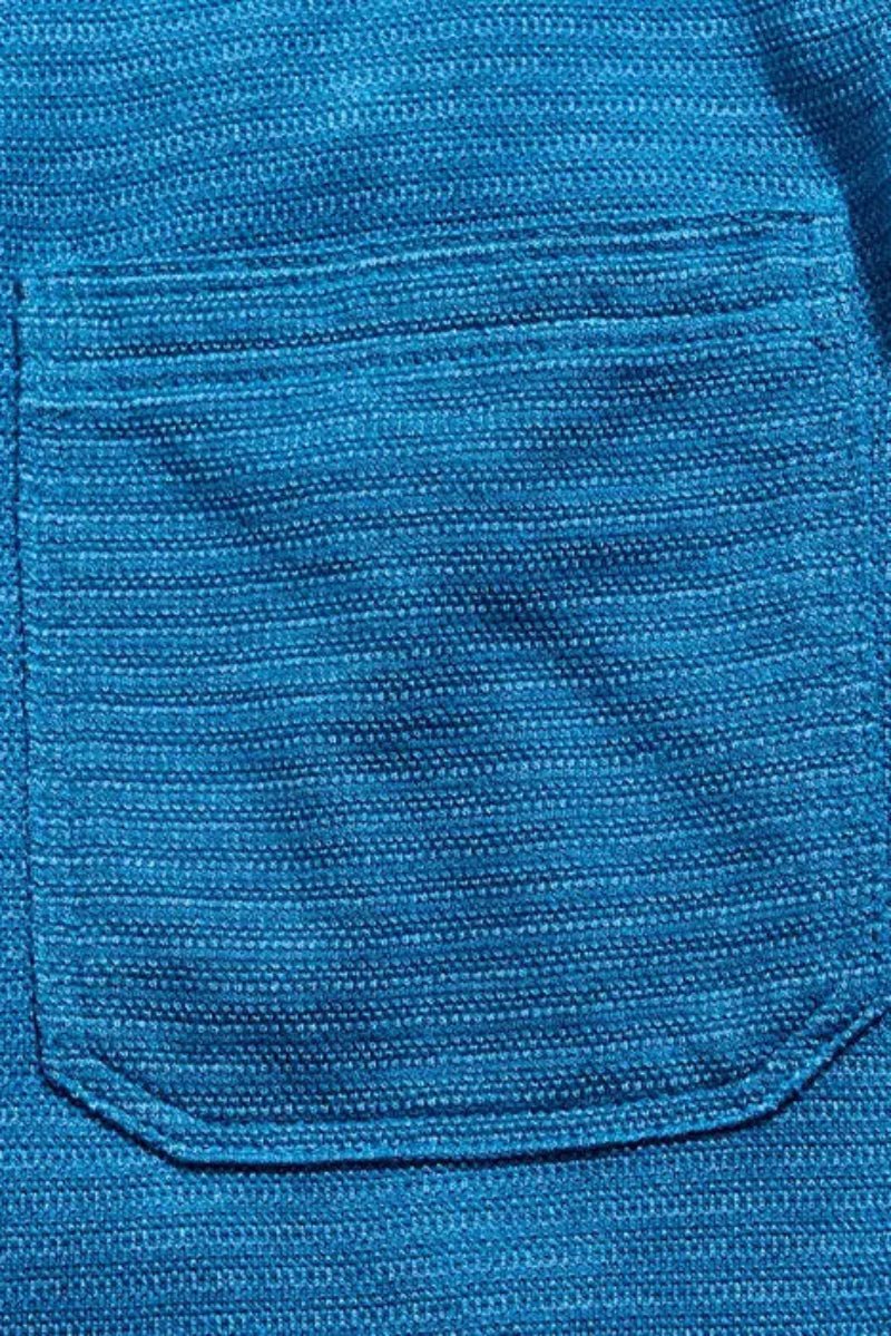 Close-up of a blue textured fabric with a pocket