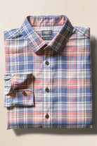 Folded plaid shirt on a beige background