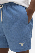 Blue shorts with a Barbour logo on a white background