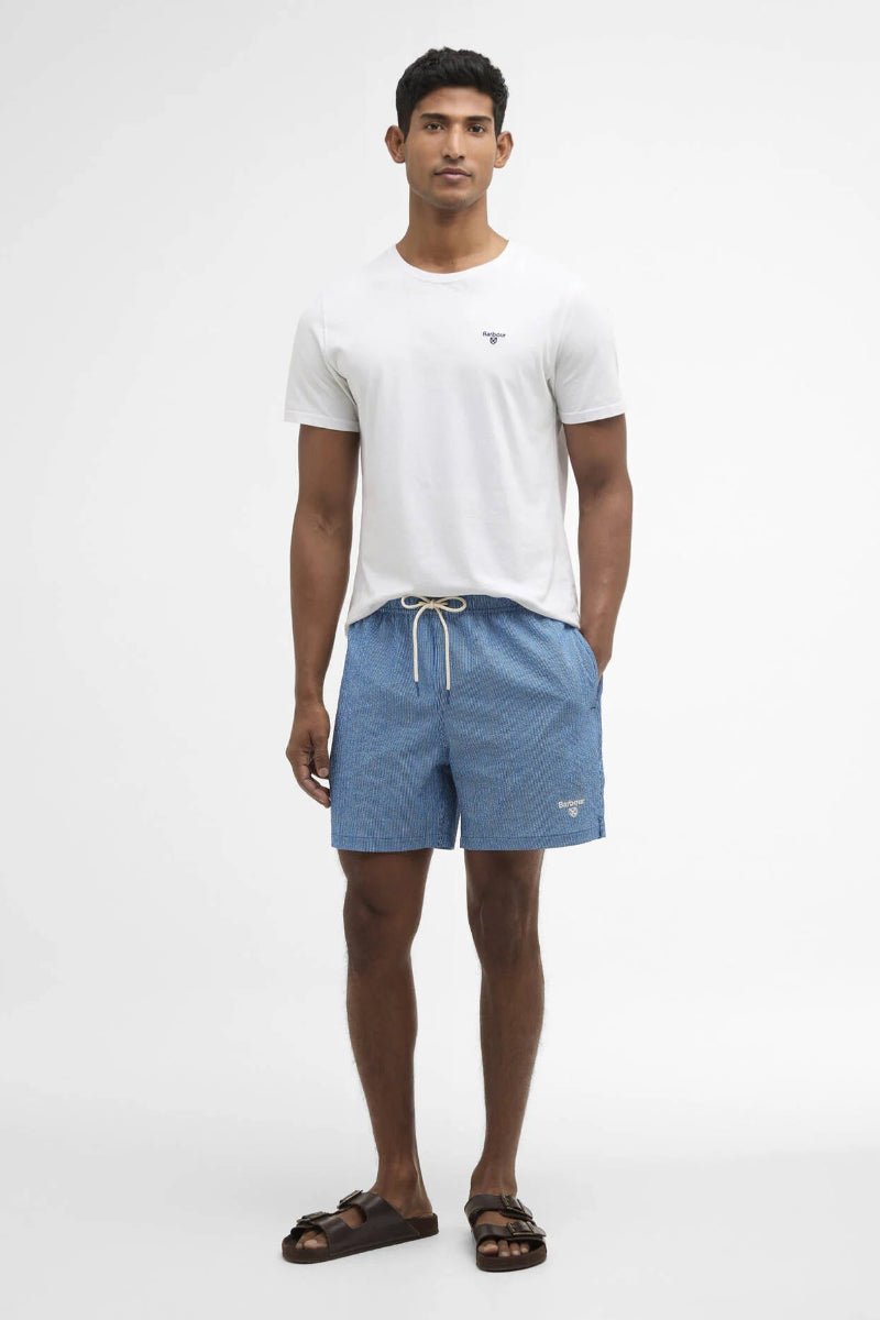 Man wearing a white t-shirt and blue shorts on a white background