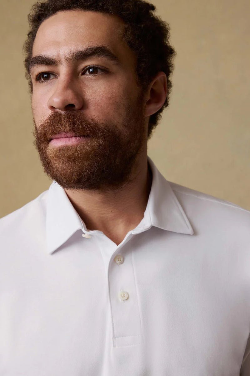 Man wearing a white shirt against a beige background