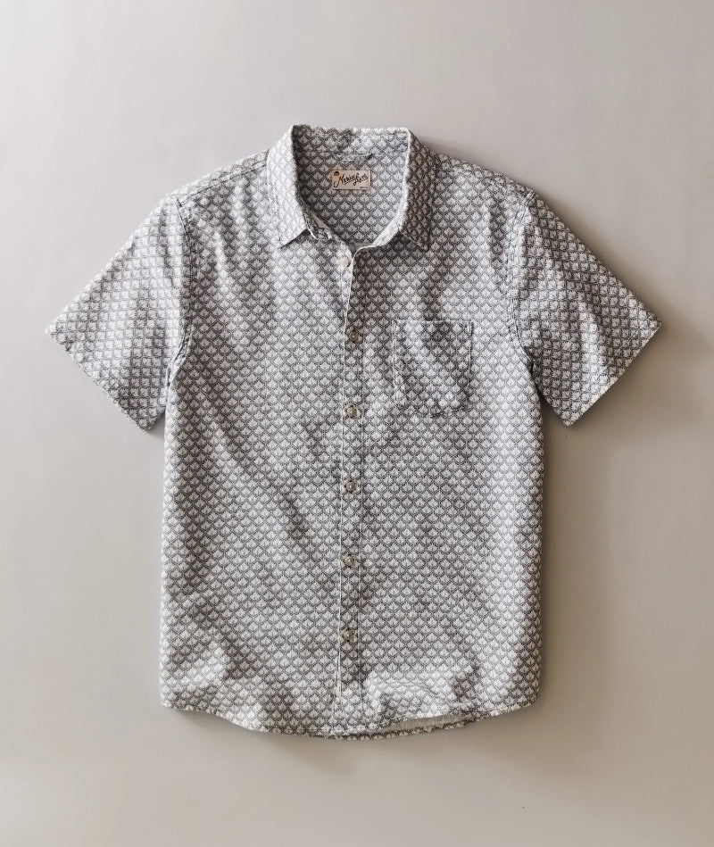 Short-sleeve button-up shirt with geometric pattern on a beige background