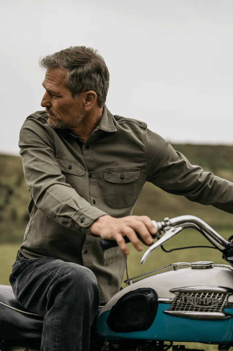 Man sitting on a motorcycle in a natural setting