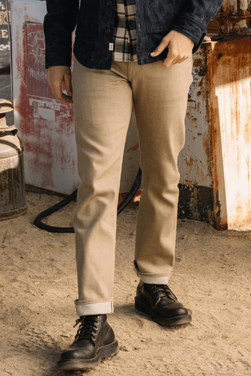 Person wearing beige pants and black boots in a rustic setting