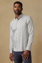 Man wearing a checkered shirt against a beige background