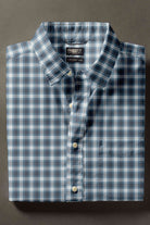 Blue plaid shirt with a label on a dark background