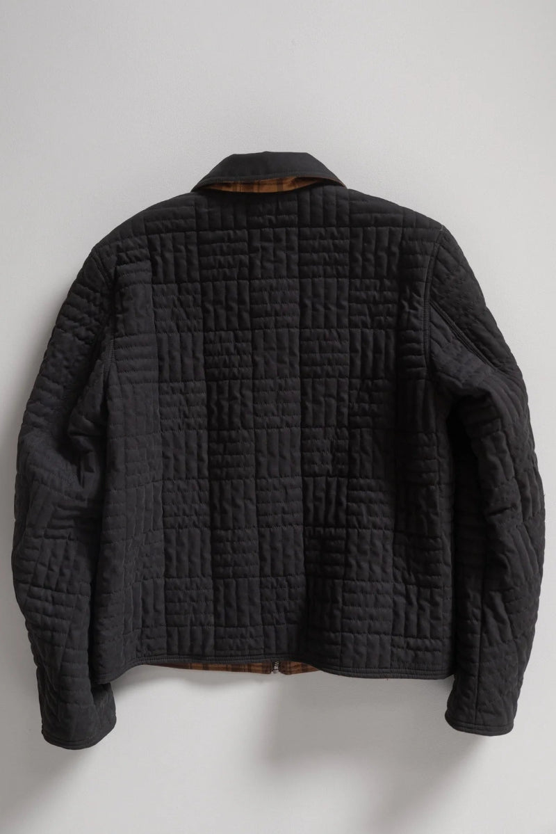 Black quilted jacket on a white background