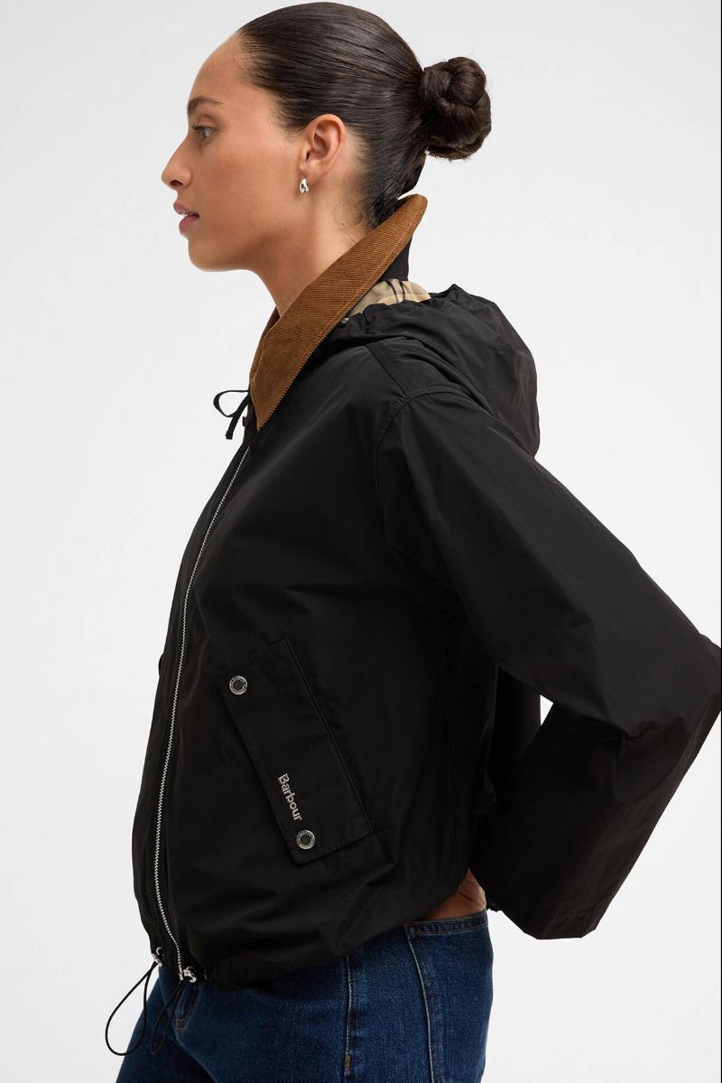 Woman wearing a black jacket with a brown hood on a white background