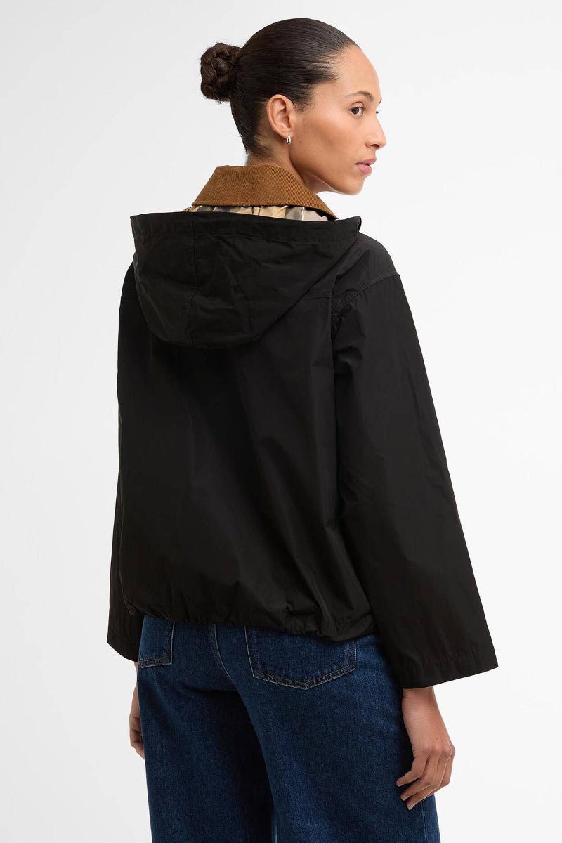 Person wearing a black jacket with a hood on a white background