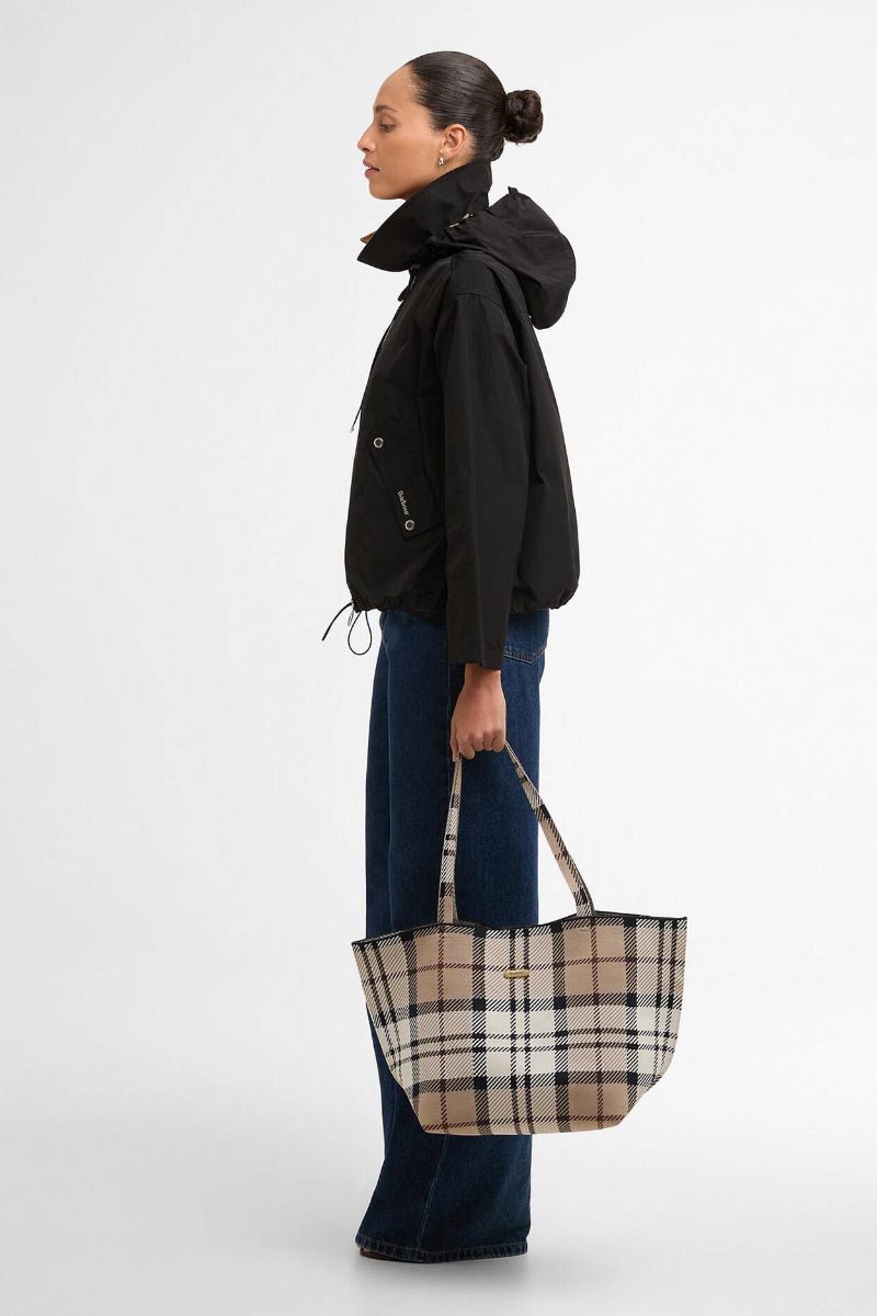 Woman holding a checkered bag against a white background