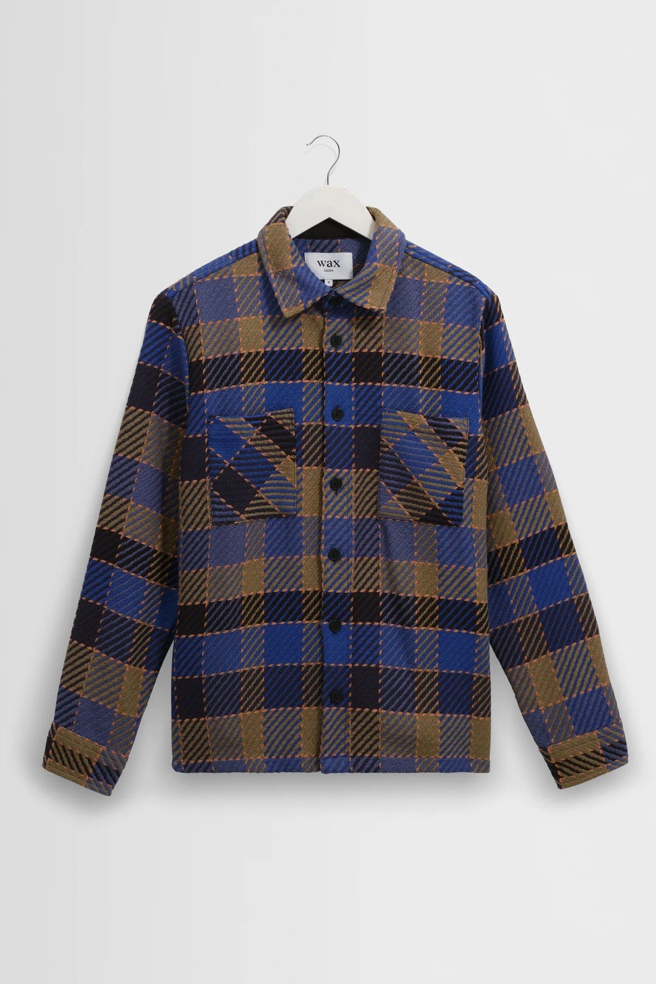 Plaid shirt on a hanger against a white background