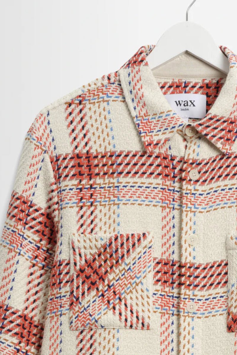 Plaid patterned jacket on a hanger with 'wax' label