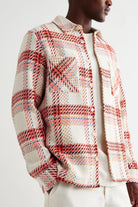 Person wearing a plaid jacket with red, white, and blue pattern on a white background