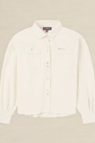 An off-white long-sleeve button-up shirt with two chest pockets, laid flat against a light beige background.